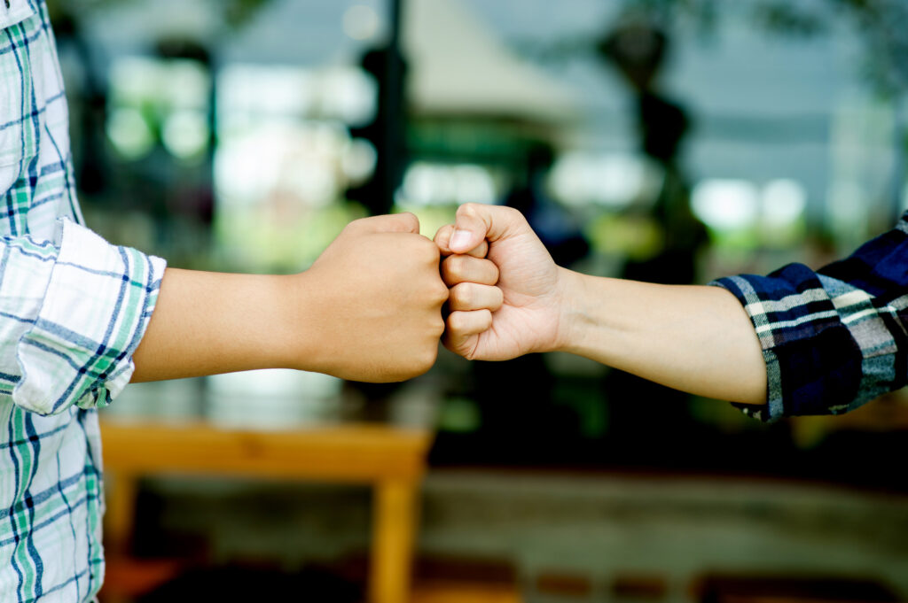 Two fists teamwork unity Close-up of two hands showing fist bumps as people finish a successful project with a team office business.